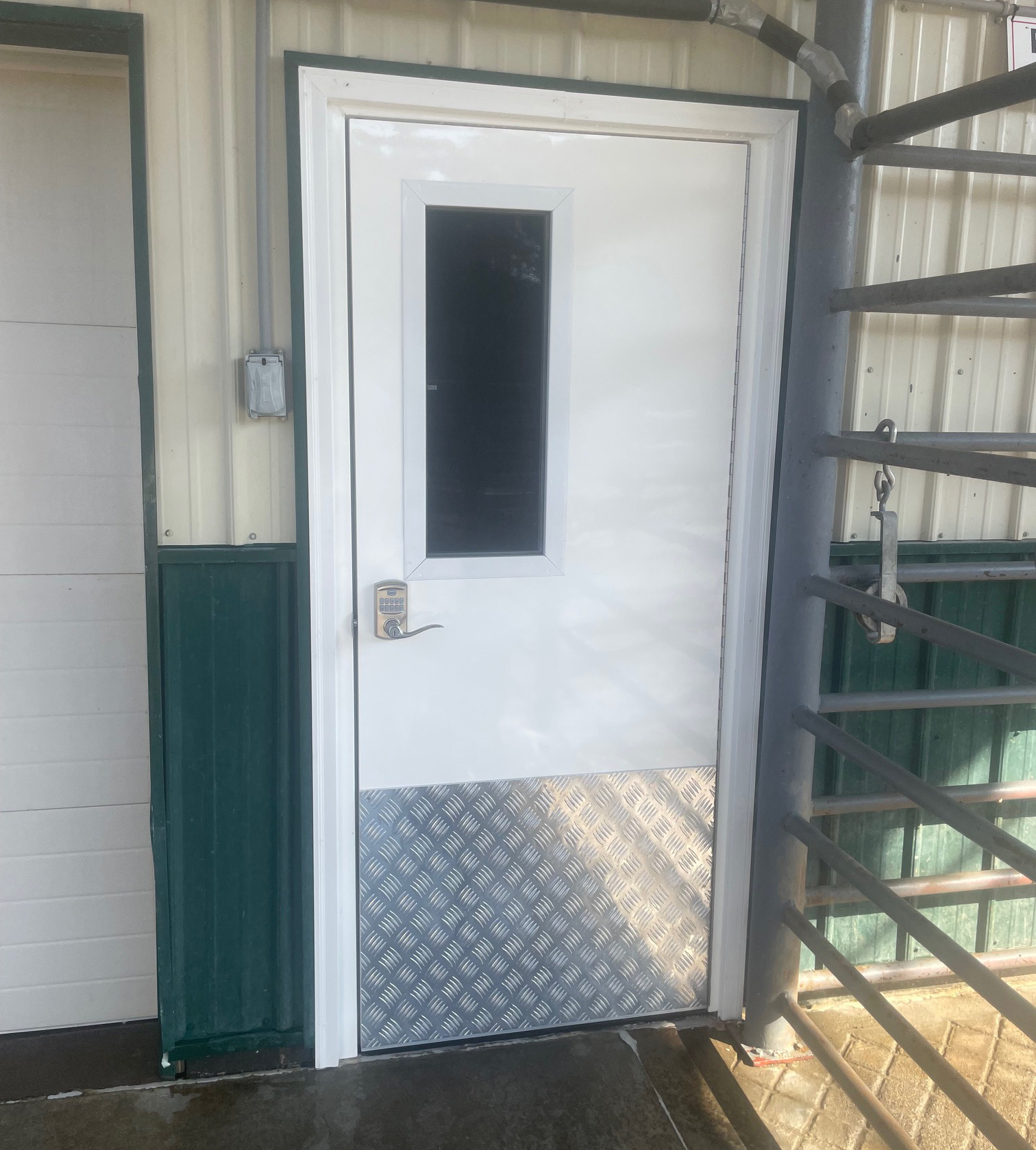 White exterior door with vision window and diamond plate kick plate on a metal building White exterior door with vision window and diamond plate kick plate on a metal building